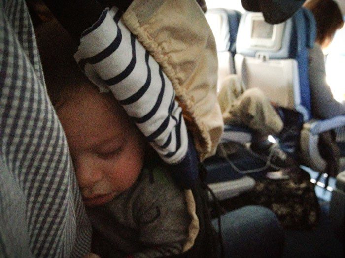 Woman holding a baby in-flight